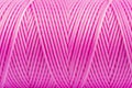 A coil of pink thread. Spool of colored threads on a white background. Waxed sewing thread for leather crafts.