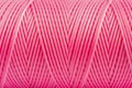 A coil of pink thread. Spool of colored threads on a white background. Waxed sewing thread for leather crafts.