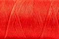 A coil of red thread. Spool of colored threads on a white background. Waxed sewing thread for leather crafts.