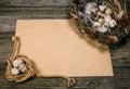 Coil of rope with quail eggs in one side and nest in other side of sheet of paper for text on rustic wood Royalty Free Stock Photo