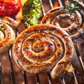 Coil of spicy beef sausage grilling on a BBQ Royalty Free Stock Photo