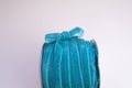 A coil of velvet turquoise ribbon for floristics and gift wrapping with a cute bow on the side