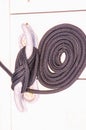 Coiled, black, nylon, line, attached to a metal cleat, securing vessel to dock