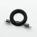 A coiled black USB charging cable with connectors at each end. One end is a USB Royalty Free Stock Photo