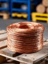 Coiled copper wire sitting on a wooden pallet in warehouse. Royalty Free Stock Photo