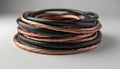 Coiled electrical wire spool features copper strands with black insulating plastic. Close-up studio shot of stacked wiring, Royalty Free Stock Photo