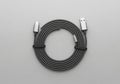 Coiled gray USB-C to USB cable on a light gray background. The cable is neatly arranged in a Royalty Free Stock Photo