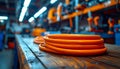Coiled orange cable on wooden workbench in industrial workshop with blurred background Royalty Free Stock Photo