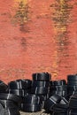 Coiled plastic pipes stored outdoors near the old red brick wall