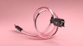 A coiled translucent pink cable with a black connector on a soft pink background Royalty Free Stock Photo