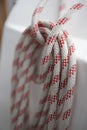 Coiled up red white braided nautical rope, sheet on deck of a sailing boat Royalty Free Stock Photo