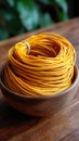 Coiled Yellow Wire Bundle in Wooden Bowl on Rustic Table Surface Royalty Free Stock Photo