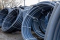 Coils of black polyethylene pipes for laying high voltage electrical cables underground at a construction site