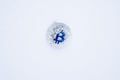 Coin of Bitcoin crypto currency thrown into the snow. Silver bit