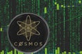 Coin cosmos atom cryptocurrency on the background of binary crypto matrix text and price chart.