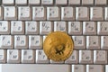 Coin crypto currency bitcoin lies on the keyboard background theme gold exchange pyramid for money due to rise or fall exchange ra Royalty Free Stock Photo