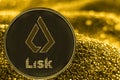 The Coin cryptocurrency Lisk token on golden background.