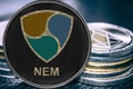 Coin cryptocurrency NEM XEM on the background of a stack of coins. Royalty Free Stock Photo