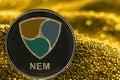 Coin cryptocurrency NEM on golden background. crypto XEM token. Royalty Free Stock Photo