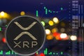 Coin cryptocurrency ripple on night city background and chart.