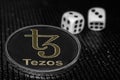Coin cryptocurrency Tezos XTZ and rolling dice.