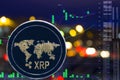 Coin cryptocurrency XRP on night city background and chart.