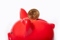 Coin 1 dollar in a hole in a red piggy bank on a white background. Savings concept. The stability of the national Royalty Free Stock Photo