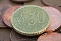 Coin of fifty euro cents on several bronze coins of five euro cents Royalty Free Stock Photo