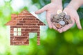 Coin Hand holding house icon in nature as symbol of mortgage,Dream house on nature background Royalty Free Stock Photo