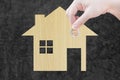 Coin Hand holding house icon from wooden texture in nature as symbol of mortgage Royalty Free Stock Photo