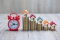 Coin ladder.Stacking coins on desk with clock. Finance and money concept.Stacked coins to save for the house with wooden table Royalty Free Stock Photo