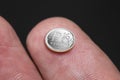 Coin of one Russian ruble of miniature size on a fingertip - the concept of inflation of the Russian currency. The fall