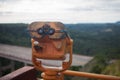 Coin Operated Binocular viewer next to the waterside promenade. Landscape with, sea and mountains..