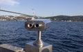 Coin-operated binoculars close-up. View of the Bosphorus Bridge in the background. Photographed outdoor in sunny