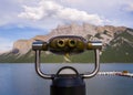 Coin operated binoculars on Lake Minnewanka. Summer vacation in the mountains - a trip to Banff, Alberta, Canada