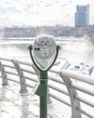 Coin operated tourism binoculars on a viewing platform overlooking an icy wintery landscape and waterfall. Niagara Falls Royalty Free Stock Photo