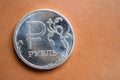 Coin Russian ruble with the image of the ruble symbol on the front. the background is brown