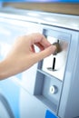 Coin slot of coin laundry vending machine, coin inserting by hand Royalty Free Stock Photo