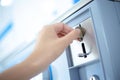 Coin slot of coin laundry vending machine, coin inserting by hand Royalty Free Stock Photo