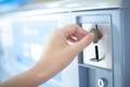 Coin slot of coin laundry vending machine, coin inserting by hand Royalty Free Stock Photo