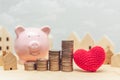 Coin stack with wooden home model and piggy bank for saving money to buy a new home with love heart concept Royalty Free Stock Photo