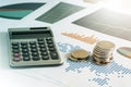 Coin stacks and calculator on paper of financial graph. Business Royalty Free Stock Photo