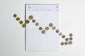 Coins array to show graph going down on bank saving account book Royalty Free Stock Photo