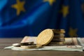 Coins and banknotes on wooden table against European Union flag, space for text Royalty Free Stock Photo