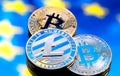 Coins Bitcoin and litecoin, against the background of Europe and Royalty Free Stock Photo