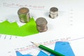 Coins on blue green graphs and charts background with pencil. mo Royalty Free Stock Photo