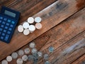 Coins and calculator over wooden background