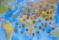 Coins of different countries on the world map background