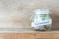 Coins and dollar bills in glass jar with retirement label Royalty Free Stock Photo