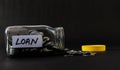 Coins empty out from a glass jar in Loan concept shot against black background and yellow cap aside Royalty Free Stock Photo